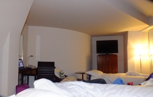 inside the clock, this rounded wall with one flat panel for the desk and one for the television and refrigerator